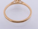 a close up of a yellow gold ring with a diamond