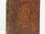an old book sitting on top of a white surface
