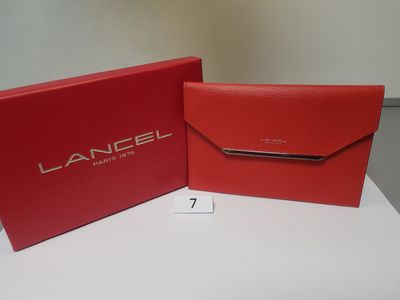 a red box and a red wallet sitting on top of a white table