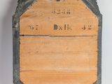 a wooden plaque on a stand on a white surface