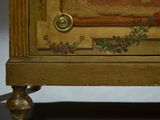a wooden cabinet with a painting on it