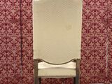 a pair of antique chairs in front of a wallpapered wall