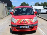 une petite voiture rouge garée sur le bord de la route