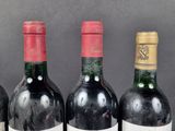 three bottles of red wine are lined up on a table