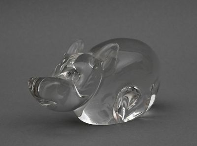 figurine de cochon en verre transparent posée sur une surface grise