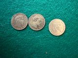 three coins sitting next to each other on a green surface