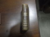 un vieux livre posé sur une table en bois, à côté d'un sac