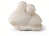 a white sculpture of a mother and child on a white surface