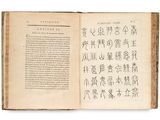 an open book with chinese writing on it on a white surface