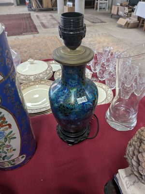 a blue vase sitting on a table with a red table cloth