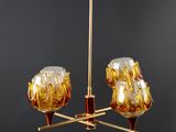 an image of a gold chandelier with three glass lamps on it