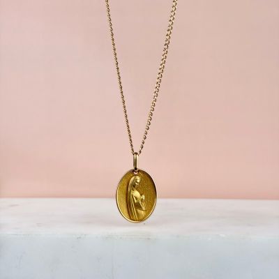 un collier composé d'une pièce d'or sur laquelle est gravé le visage d'une femme