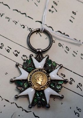 une médaille posée sur un bout de papier, lui-même posé sur un autre bout de papier