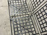 a metal bench that is sitting on the sidewalk