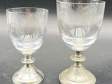 two wine glasses sitting on a table next to each other