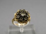a close up of a gold ring with a black diamond on it