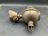 an antique brass oil lamp on a metal surface with a black background