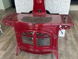 a red stove sitting in the middle of a living room