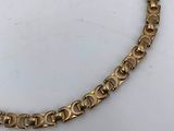 a close up of a gold necklace on a white surface