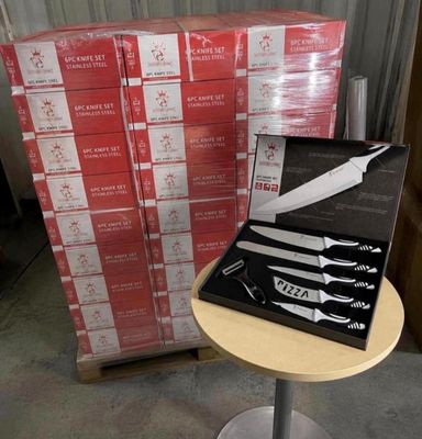a box of knives on a table next to a stack of boxes