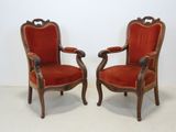 paire de fauteuils recouverts de velours rouge, avec des accoudoirs en bois sculpté
