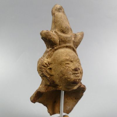 an image of a statue of a bird on top of a wooden stick