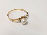 a close up of a gold ring with a pearl and diamonds