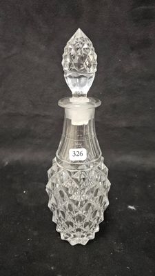 an antique glass perfume bottle with a stopper on a black background