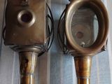 two antique brass lamps on a striped table cloth