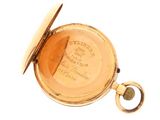 a close up of a pocket watch on a white surface