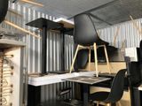 a room with a desk, chairs, and a laptop on it