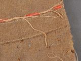 a piece of brown paper with a red string on it