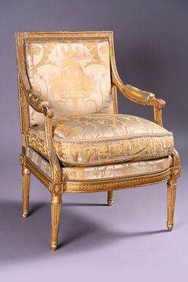 an antique chair with a gold upholstered upholstered back and arms