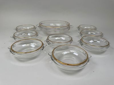 six bols en verre transparent aux bords dorés sont disposés sur une surface blanche