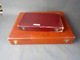 a red suitcase sitting on top of a wooden box