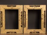 two wooden frames with holes in them on a wooden surface