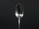 a close up of a spoon on a table with a black background