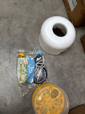 two rolls of toilet paper, a cup of coffee, and some other items on the floor