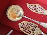two silver spoons and a silver spoon in a red box