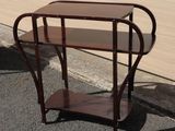 a small table with a shelf on the side of the road