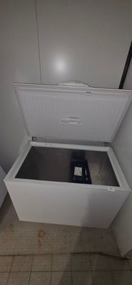 a white chest freezer sitting in the corner of a room