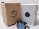 a watch sitting next to a box with a watch in it