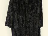 black fur coat on hanger against white background