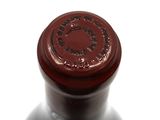 a close up of a bottle of wine on a white surface