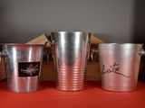 three silver buckets sitting next to each other on a red table