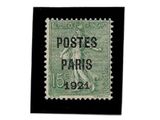 Le timbre est vert et noir et représente un homme tenant une raquette de tennis.