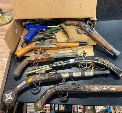 tout un tas d'armes à feu qui traînent dans une boîte