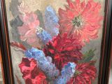 painting of red and blue flowers in a wooden frame on a table