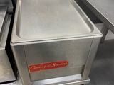 two stainless steel pans sitting on top of a metal counter