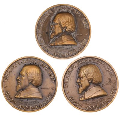 three bronze medallions depicting two men and a woman